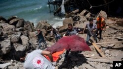 17일 이스라엘의 공습으로 무너진 가자시티의 한 건물에서 구조대원들이 사망자 시신을 수습하고 있다.