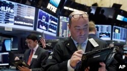 FILE - Trader Christopher Morie, right, works on the floor of the New York Stock Exchange.