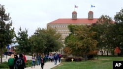 FILE - Students walk on the University of Kansas campus, in Lawrence, Kansas, Oct. 24, 2019. 