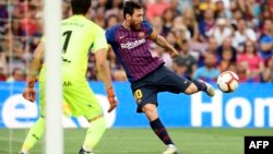 L'attaquant argentin de Barcelone Lionel Messi tire sur le gardien de but argentin du SD Huesca, Axel Werner, lors du match de football entre le FC Barcelona et SD Huesca, au stade Camp Nou de Barcelone, le 2 septembre 2018.