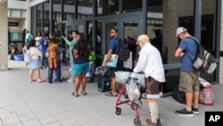 Pasco County evacuees await the opening of the shelter at River Ridge High School in preparation for Hurricane Milton, in New Port Richey, Florida, Oct. 7, 2024.