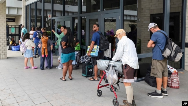 Pasco County evacuees await the opening of the shelter at River Ridge High School in preparation for Hurricane Milton, in New Port Richey, Florida, Oct. 7, 2024.