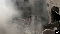 Palestinyen yo ap enspekte debri yon kay apre yon misil lame izrayelyèn nan tonbe nan vil Gaza, (10 jiyè, 2014.) 