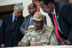 Gen. Mohammed Hamdan Dagalo signs a power sharing document with Sudan's pro-democracy movement and the ruling military council in Khartoum, Sudan, July 17, 2019.