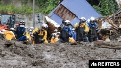 Police officers conduct a rescue and search operation at the site of a mudslide caused by heavy rain at Izusan district in Atami, Japan, July 5, 2021. (Kyodo/via Reuters)