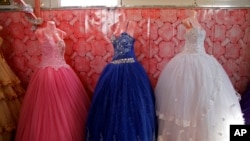 FILE - Bridal gowns and engagement dresses are displayed in a small shop in the Zaatari camp for Syrian refugees in northern Jordan, Aug. 6, 2017. Nearly 10,500 girls in Jordan were married before reaching their 18th birthdays in 2017. 