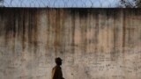 FILE - A prison guard walks along a perimeter wall at a prison in Rumbek, Lakes State, South Sudan, Feb. 19, 2014. 