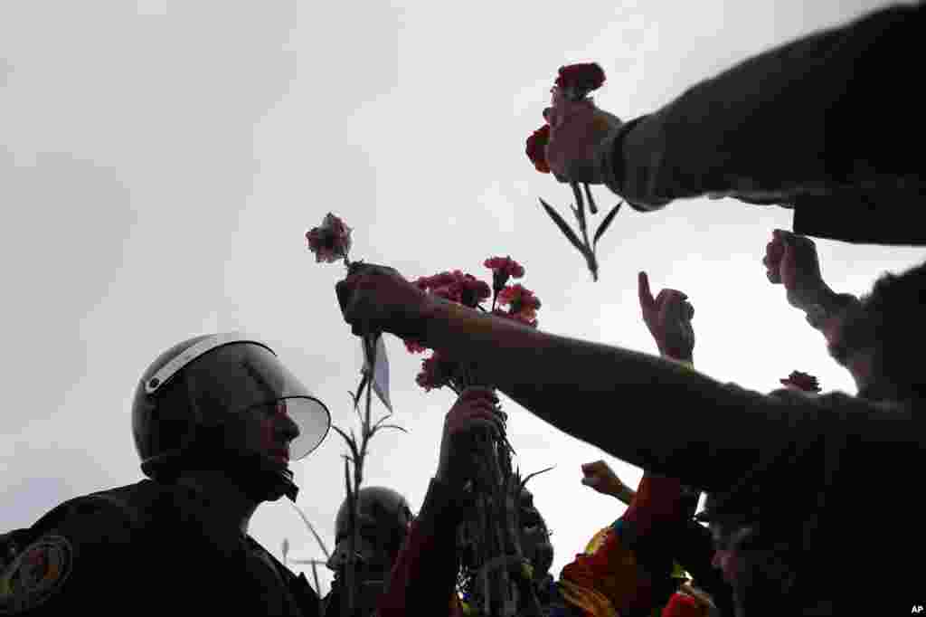 La gente ofrece flores a un guardia civil en la entrada de un centro deportivo, asignado como una mesa de votación para el referéndum independentista dirigido por el gobierno catalán en Sant Julià de Ramis, cerca de Girona, el 1 de octubre de 2017.