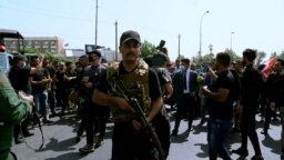 Sejumlah anggota kelompok militan yang didukung Iran, berparade di pusat Kota Baghdad, Irak, pada 29 Juni 2021. (Foto: AP/Khalid Mohammed)