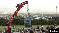 Des étudiants applaudissent le déplacement de la statue de Cecil John Rhodes à l'Université de Cape Town en Afrique du Sud, le 9 avril 2015. (REUTERS/Sumaya Hisham)