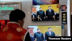 FILE - Television screens show Chinese state media CCTV's footage of North Korean leader Kim Jong Un's meeting with Chinese President Xi Jinping, in Beijing, Jan. 10, 2019.