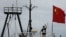 Captain Why Yang of Hong Kong fishing vessel "Kai Fung No.2" waves next to a Chinese national flag as he reaches in Hong Kong's island of Cheung Chau, August 22, 2012. 