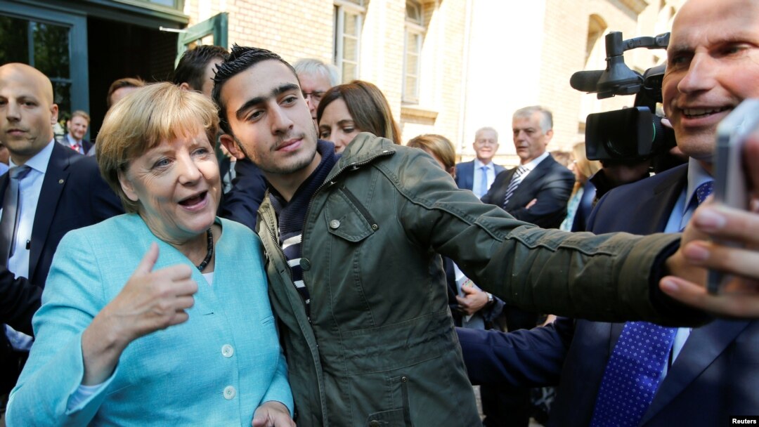 FILE - Syrian refugee Anas Modamani takes a selfie with German Chancellor Angela Merkel outside a refugee camp near the Federal Office for Migration and Refugees after registration at Berlin's Spandau district, Germany, Sept. 10, 2015. 