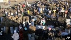 FILE - People gather to buy charcoal at a busy market in Lusaka, Zambia, July 5, 2021.