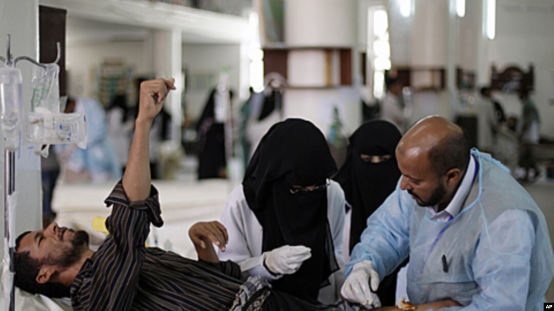 Yemeni medics treat a man who injured at the site of clashes with security forces, in Sana'a, Yemen, September 22, 2011.