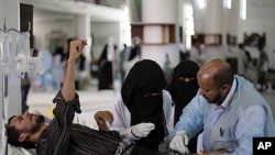 Yemeni medics treat a man who injured at the site of clashes with security forces, in Sana'a, Yemen, September 22, 2011.