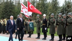 Turkish Prime Minister Binali Yildirim, left, and Tufan Erhurman, the prime minister of the self-declared Turkish Cypriot state in the north of the divided island, review a military honour guard during a ceremony at the Cankaya Palace in Ankara, Turkey, Wednesday, March 7, 2018.