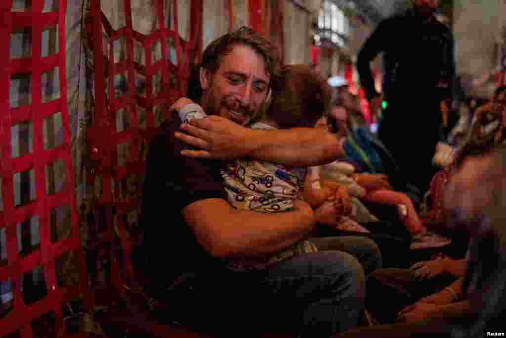 A father hugs his son as Greek and Greek Cypriot nationals are evacuated from Lebanon on a Hellenic Air Force C130, due to ongoing hostilities between Hezbollah and the Israeli forces, in Beirut, Lebanon.