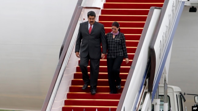 ARCHIVO - El presidente de Venezuela, Nicolás Maduro, y la primera dama Cilia Flores bajan por las escalinatas del avión a su servicio en el Aeropuerto Internacional de Beijing, China, el 1 de septiembre de 2015.