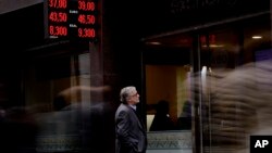 A man looks at the price of the U.S. dollar and Brazilian real at a money exchange house in Buenos Aires, Argentina, Monday, Sept. 3, 2018. Argentina's President Mauricio Macri has announced new taxes on exports and the elimination of several ministries on Monday in a bid to halt economic turmoil that has sent the peso to record lows.