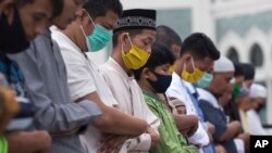 Muslims wearing face masks offer the Eid al Fitr prayer together amid the coronavirus outbreak at Al Mashun Grand Mosque in Medan, North Sumatra, Indonesia, May 24, 2020.