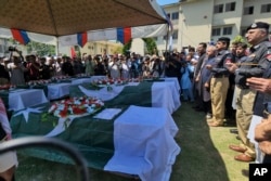Pejabat dan lainnya menghadiri doa pemakaman petugas polisi, yang tewas dalam insiden ledakan amunisi di Kabal, sebuah kota di Distrik Swat, Pakistan, Selasa, 25 April 2023. (Foto: AP)