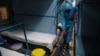 Zdravstveni radnik u zaštitnoj opremi čisti kabinu u vozu koji služi kao improvizovani centar za staranje o zaraženima Kovidom 19 u Indiji (Foto: AP)