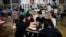 Para imigran China yang dideportasi dari Amerika, makan di food court stasiun bus setelah tiba di Panama City, Sabtu, 8 Maret 2025.