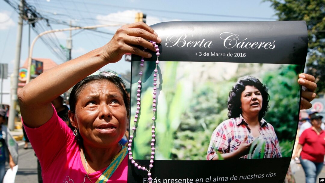 A woman holds up a poster with a photo of slain environmental leader Berta Caceres, during a protest march in Tegucigalpa, Honduras, March 16, 2016. Authorities said unidentified gunmen killed Nelson Garcia, a colleague of Caceres, on March 15.