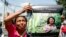 A woman holds up a poster with a photo of slain environmental leader Berta Caceres, during a protest march in Tegucigalpa, Honduras, March 16, 2016. Authorities said unidentified gunmen killed Nelson Garcia, a colleague of Caceres, on March 15.
