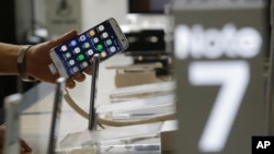 A customer holds a Samsung Electronics Galaxy Note 7 smartphone at the headquarters of South Korean mobile carrier KT in Seoul, South Korea, Friday, Sept. 2, 2016.