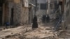 Palestinians walk on a damaged road following an Israeli military operation in the West Bank city of Jenin, Sept. 6, 2024.