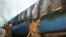An Indian fire official douses fire coming out from a coach of a passenger train at Nellor nearly 500 kilometers (310 miles) south of Hyderabad, India, Monday, July 30, 2012.