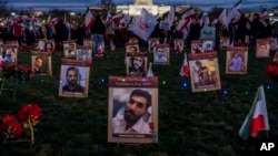 FILE - Protesters walk through a vigil honoring Iranians allegedly killed by their government during a rally in support of the ongoing protests in Iran at the National Mall, Dec. 17, 2022, in Washington. 