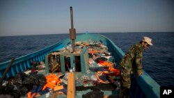 Seorang penjaga pantai LIbyan berdiri di atas sebuah kapal kayu dimana lebih dari tujuh ratus migran sedang berlayar untuk melarikan diri dari Libya, selama operasi penyelamatan di laut Mediterania, sekitar 13 mil sebelah utara Sabratha, Libya, Senin, 29 Agustus 2016. (Foto: dok).