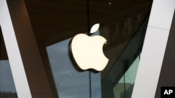 FILE - An Apple logo is seen on the facade of a downtown Brooklyn Apple store in New York, March 14, 2020. 