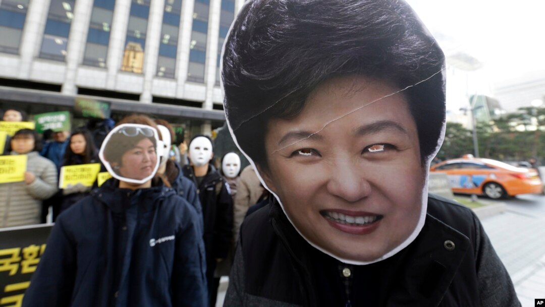 South Korean protesters wearing masks of South Korean President Park Geun-hye, right, and Choi Soon-sil, who is at the center of a political scandal, stage a rally calling for Park to step down in downtown Seoul, South Korea, Nov. 2, 2016.