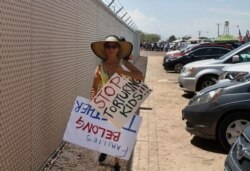 A grandmother protesting the treatment of children in Border Patrol custody walks back to her car by a fence at a holding center in Clint, Texas, July 1, 2019. Yvonne Nieves, in her 50s, says she has a 2-year-old granddaughter.