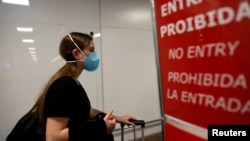 A traveler wears a face mask to protect against the coronavirus, at Salgado Filho Airport in Porto Alegre, Brazil, Feb. 27, 2020. 