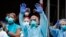 Trabajadores médicos animan y reconocen a los peatones y a los bomberos del FDNY que se reunieron para aplaudirlos a las 7 pm en las afueras del Brooklyn Hospital Center, el 14 de abril de 2020, en Nueva York.