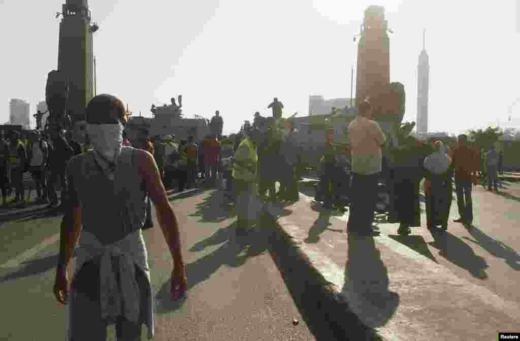 Opponents of deposed President Mohamed Morsi stand among police officers after a report of a possible pro-Morsi rally near Tahrir square in Cairo, July 23, 2013. 