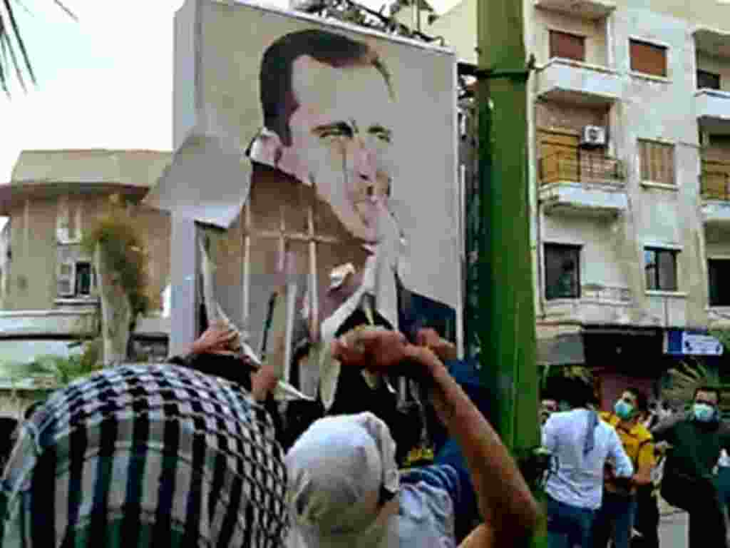 A video downloaded from YouTube shows Syrian anti-government protesters tearing down a portrait of President Basahr al-Assad in Hama on April 29, 2011 during the "Day of Rage" demonstrations