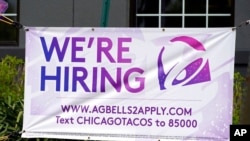 FILE - A hiring sign is displayed outside a restaurant during the COVID-19 pandemic in Glenview, Ill., May 8, 2021. 