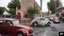 Volkswagen Beetles circulan y ofrecen servicios de taxi en el empinado vecindario de Cuautepec, en Ciudad de México, el 21 de junio de 2024. Hay tantos Beetles, o "vochos", en el vecindario, que se ha ganado el apodo de "Vocholandia".