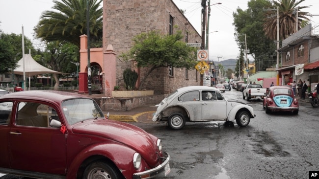 Volkswagen Beetles circulan y ofrecen servicios de taxi en el empinado vecindario de Cuautepec, en Ciudad de México, el 21 de junio de 2024. Hay tantos Beetles, o "vochos", en el vecindario, que se ha ganado el apodo de "Vocholandia".