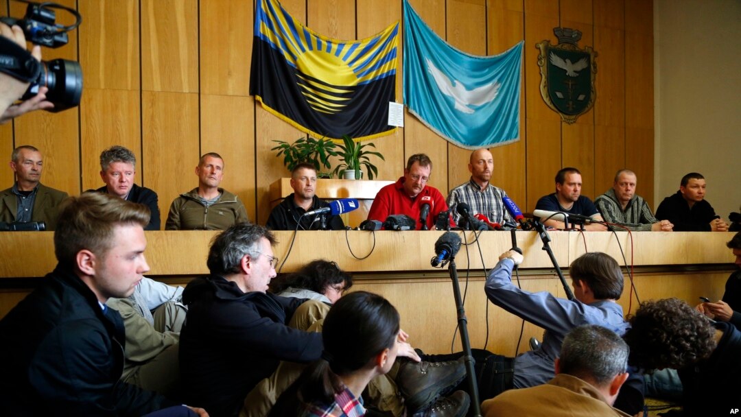Vyacheslav Ponomaryov, the self-proclaimed mayor of Slovyansk, fourth from left, is flanked by a group of foreign military observers being held by Ponomaryov's group during a press conference in city hall, Slovyansk, eastern Ukraine, April 27, 2014.
