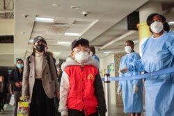FILE - Passengers arriving from a China Southern Airlines flight from Changsha in China are screened for the coronavirus upon their arrival at the Jomo Kenyatta international airport in Nairobi, Kenya, Jan. 29, 2020.