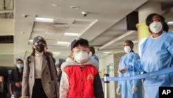 Passengers arriving from a China Southern Airlines flight from Changsha in China are screened for the new type of coronavirus, upon their arrival at the Jomo Kenyatta international airport in Nairobi, Kenya, Jan. 29, 2020. 