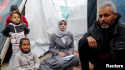 FILE - Aseel Abu Haddaf, a Palestinian medical student who fled her house in Khan Younis with her family, looks on as she sits next to her father at a tent camp, in Rafah in the southern Gaza Strip January 28, 2024.