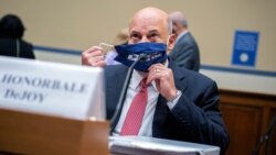 Postmaster General Louis DeJoy removes his face mask as he arrives to testify before a House Oversight and Reform Committee hearing on the Postal Service on Capitol Hill, Aug. 24, 2020, in Washington.